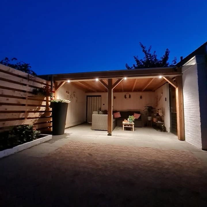 Verlichte houten veranda met bestrating in de avond