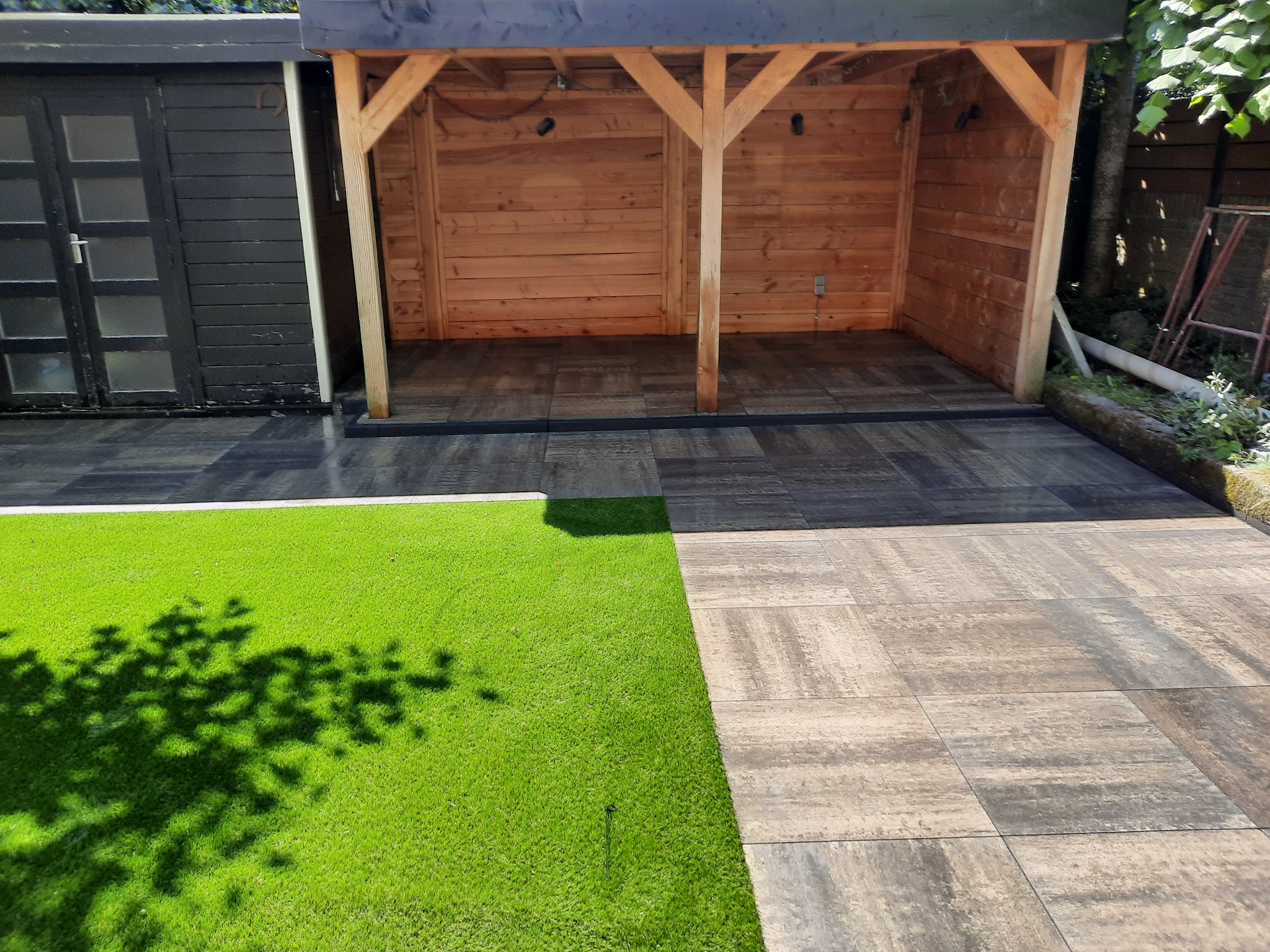 Houtlook tegels naast het gazon voor een houten veranda
